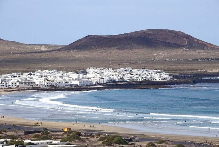Surfistas en la playa de Famara pillando olas