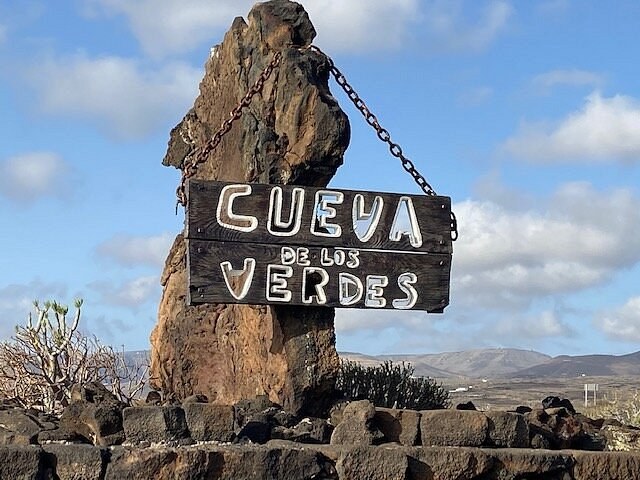 piedra con cartel de madera en la entrada de la cueva de los verdes en Lanzarote